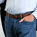 A man wearing the reversible SureFit Belt, brown side facing out, with his hand in his left pocket and thumb hanging out.